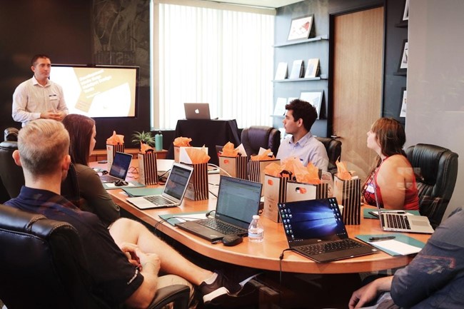 A team in an office discussing knowledge management during a mee