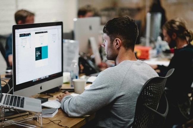 A man in an office researching knowledge management technology during a meeting